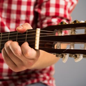 Music, close-up. Musician holding a wooden guitar