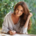 Portrait of an attractive young woman writing in a relaxed environment outdoors